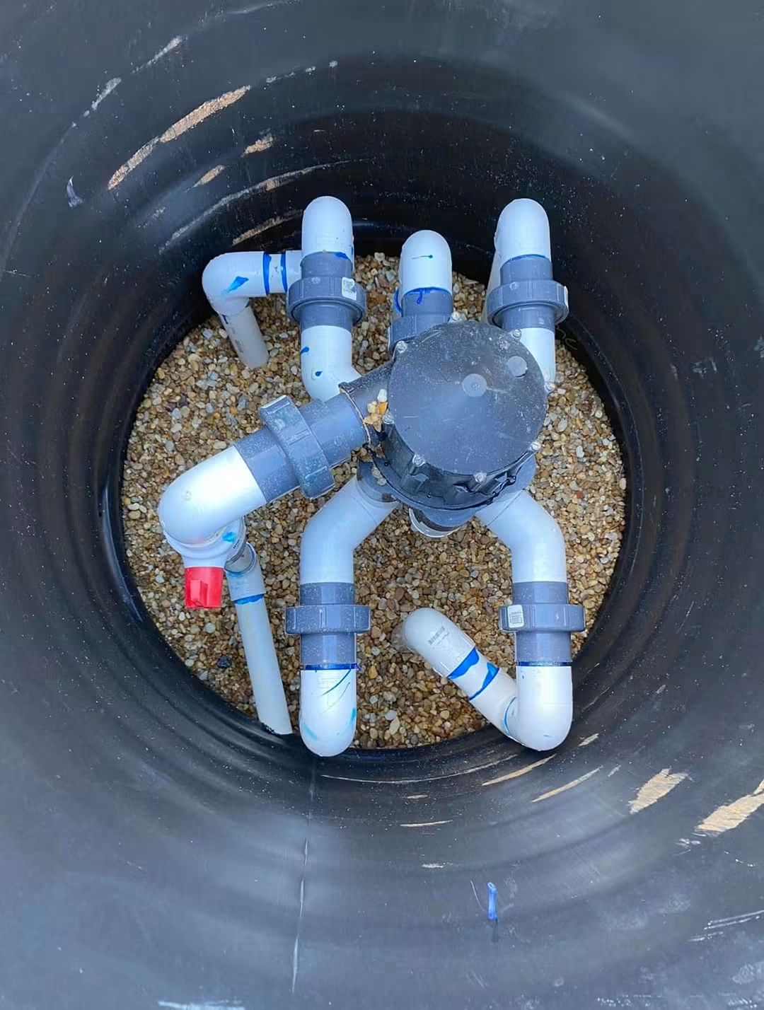 Completed valve manifold inside a fiberglass vault over washed stone