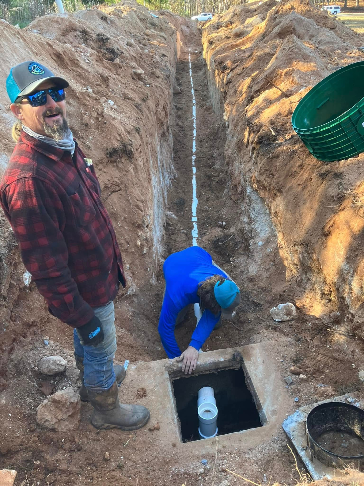 EMS crew installing wastewater lines in a trench.