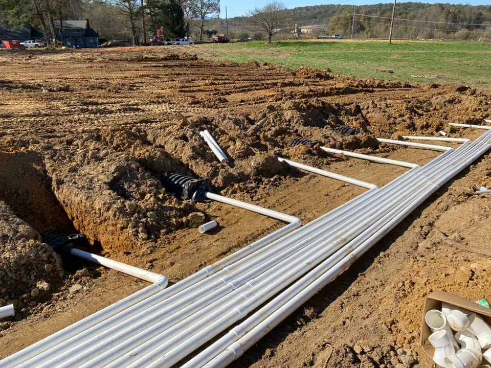 PVC distribution lines laid in excavated trenches at an EMS construction site